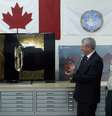 Primeiro-ministro do canadá, Stephen Harper (à esquerda) aplaude após ser apresentado às imagens dos destroços encontrados  Foto: Chris Wattie  / Reuters