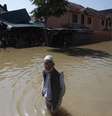 Cidadãos da Caxemira caminham em meio a água e casas danificadas, em uma rua inundada, em Srinagar , em 14 de setembro  Foto: Danish Ismail / Reuters