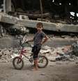 Criança palestina anda de bicicleta em meio aos escombros deixados pelo conflito na Faixa de Gaza  Foto: Mohammed Salem  / Reuters