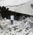 Menino anda entre escombros de prédio destruído durante ataques desta terça-feira  Foto: Ammar Abdullah  / Reuters