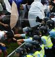 <p>Manifestantes com guarda-chuvas bloqueiam rua perto da sede do governo de Hong Kong</p>  Foto: Carlos Barria / Reuters