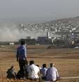 Curdos turcos observam a cidade síria curda de Kobani do topo de uma colina perto da fronteira entre Turquia e Síria, na região do portão de Mursitpinar, nesta sexta-feira. 10/10/2014  Foto: Umit Bektas / Reuters