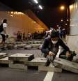 <p>Um manifestante pró-democracia deposita tijolos dentro de um túnel para bloquear o tráfego que conduz ao distrito financeiro central, perto da sede do governo em Hong Kong, em 14 de outubro </p>  Foto: Tyrone Siu / Reuters