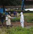 <p>Agente da saúde com vestimenta especial é desinfetado após lidar com um corpo infectado com ebola, em Monróvia, na Libéria</p>  Foto: James Giahyue / Reuters