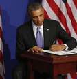 <p>O presidente dos EUA, Barack Obama, assina uma ordem executiva para reforçar a segurança dos cartões de crédito, em Washington, em 17 de outubro</p>  Foto: Larry Downing / Reuters