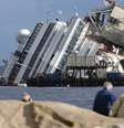 Pessoas olham navio de cruzeiro Costa Concordia tombado na costa da Toscana, na Itália. 16/09/2014  Foto: Tony Gentile / Reuters
