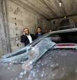 Homens observam um dos carros atingidos pelas explosões nesta sexta-feira  Foto: MOHAMMED ABED / AFP