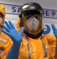 <p>Funcionário do hospital francês, Necker, mostra luvas e roupas de proteção usadas para tratamento de paciente</p>  Foto: Philippe Wojazer / Reuters