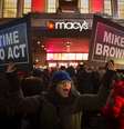 <p>Manifestantes erguem cartazes de protesto em frente a uma loja da rede Macy's, em Nova York, em apoio aos protestos em Ferguson</p>  Foto: Andrew Kelly / Reuters