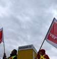 <p>Membros do sindicato Verdi com bandeiras do lado de fora de um armaz&eacute;m da Amazon</p>  Foto: Michaela Rehle / Reuters