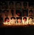<p>Um homem coloca uma rosa na&nbsp;frente de retratos das v&iacute;timas do ataque talib&atilde; na Escola P&uacute;blica do Ex&eacute;rcito em Peshawar, durante uma vig&iacute;lia &agrave; luz de velas, em Lahore&nbsp;</p>  Foto: Mohsin Raza / Reuters