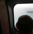Tripulante olha por janela de helicóptero da Força Aérea da Indonésia na busca por vítimas de avião da AirAsia. 06/01/2015  Foto: Achmad Ibrahim / Reuters