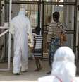 Agente da saúde acompanha novos pacientes de Ebola num centro de tratamento nos arredores de Freetown, em Serra Leoa, em dezembro. 22/12/2014  Foto: Baz Ratner / Reuters