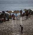 <p>Menino se refresca em chuveiro na praia do Arpoador, no Rio de Janeiro.</p>  Foto: Ricardo Moraes / Reuters