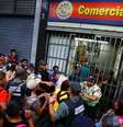 <p>Pessoas fazem fila em porta de mercado no centro de Caracas</p>  Foto: Jorge Silva / Reuters