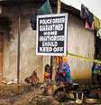 <p>Menina &eacute; fotografada em 22 de outubro de 2014 perto de uma placa de sinaliza&ccedil;&atilde;o colocada em&nbsp;uma casa em quarentena,&nbsp;em Port Loko, Serra Leoa</p>  Foto: Michael Duff / AP