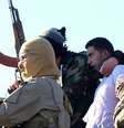 <p>O piloto jordano Mu'ath Al-Kaseasbeh nas mãos dos membros dos Estado Islâmico em Raqqa, Síria (24/12)</p>  Foto: AP