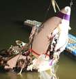 A fuselagem do avião comercial da TransAsia Airways é arrastadapara a margem do rio em Taipei, Taiwan  Foto: AP