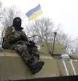 Um soldado ucraniano repousa sobre o seu veículo perto da estrada entre as cidades de Debaltseve e Artemivsk, na Ucrânia, em 16 de fevereiro  Foto: Petr David Josek / AP