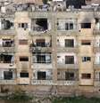 <p>Vista de um prédio danificado por disparos numa área controlada por rebeldes em Homs, na Síria</p>  Foto: Stringer / Reuters