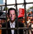 Um homem usando uma máscara do primeiro-ministro australiano, Tony Abbott, se posiciona atrás de uma grade de bambu durante protesto de estudantes contra o premiê, em Jacarta, na Indonésia, nesta quarta-feira. 25/02/2015  Foto: Beawiharta / Reuters