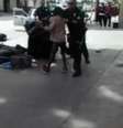 Vídeo feito por um observador mostra pelo menos quatro policiais lutando com o homem no solo ao lado do que parece ser uma série de lonas de plástico e sacos de dormir na calçada  Foto: BBC News Brasil