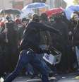 <p>Manifestante joga pedras em policiais em frente a sede do BCE, em Frankfurt</p>  Foto: Kai Pfaffenbach / Reuters