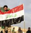 <p>Soldado iraquiano ergue símbolo de vitória próximo à bandeira nacional em Tikrit, Iraque</p>  Foto: EFE en español