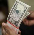 Movimento de baixa do dólar está relacionado à sinalização de aumento de juros pelo BC  Foto: Gary Cameron / Reuters