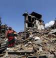 Mulher carregando seus pertences em meio a destroços por conta do terremoroto no Nepal  Foto: Adnan Abidi / Reuters