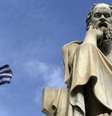 Bandeira da Grécia próxima a estátua do filósofo Sócrates, em Atenas  Foto: Yannis Behrakis / Reuters