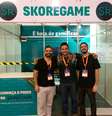 Gabriel Falcione (à esquerda), fundador da startup criadora da Skoregame, à frente de um estande da vendas da plataforma  Foto: Divulgação