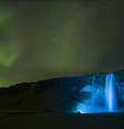 Uma noite clara criou o ambiente para esta foto da aurora boreal sobre a gigantesca cachoeira de Seljalandsfoss, na Islândia.   Foto: Paul Andrew / Observatório Real de Greewich/Divulgação