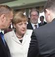 Presidente do Conselho Europeu, Donald Tusk (esq.) em conversa com a chanceler alemã Angela Merkel  Foto: Getty Images