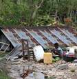 Criança cozinha ao lado de casa destruída pelo furacão Matthew no Haiti  Foto: EFE