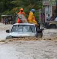 Um grupo de pessoas tenta cruzar uma via alagada in Leogane, no Haiti, após a passagem do Furacão Matthew -  Foto: Agência Brasil