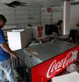 Homem procura por objetos de valor em loja de conveniência saqueada em Caracas, na Venezuela  Foto: Reuters