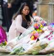 Mulher deposita flores em homenagem às vítimas do atentado após show de Ariana Grande em Manchester.  Foto: Reuters
