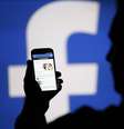 Homem acessa Facebook em celular diante de projeção do logo da rede social
14/08/2013 REUTERS/Dado Ruvic/File Photo  Foto: Reuters