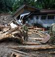Soldados japoneses caminham em meio a destroços deixados pelas chuvas em Toho. 07/07/2017 REUTERS/Issei Kato  Foto: Reuters