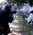 Policial usa gás de pimenta para separar grupos rivais  Foto: Reuters