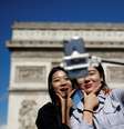 Turistas tiram foto em frente ao Arco do Triunfo, na avenida Champs-Élysées, em Paris   Foto: Reuters
