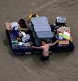Moradores de Houston transportam seus pertences por ruas alagadas da cidade  Foto: Reuters