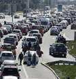 Pessoas atravessam o trânsito ao longo de uma rodovia enquanto taxistas bloqueiam o caminho para o aeroporto internacional de Santiago durante um protesto contra as tecnologias Uber e Cabify em Santiago  Foto: Reuters