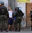 Policiais do Exército revistam pessoas em via da favela da Rocinha, no Rio de Janeiro  Foto: José Lucena/Futura Press