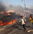 Homens deixam local da explosão na Somália  Foto: Reuters