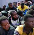 Migrantes resgatados pela marinha líbia em porto de Trípoli  Foto: Reuters