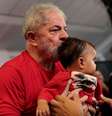 Lula beija criança no Sindicato dos Metalúrgicos de São Bernardo, onde ele acompanha o julgamento  Foto: Reuters