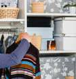 Pessoa pendurando roupa no armário organizado  Foto: Shutterstock / TudoGostoso