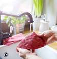Carne crua sendo lavada debaixo da água corrente  Foto: Shutterstock / TudoGostoso